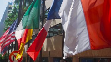 a bunch of flags that are in front of a building